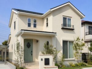グリーンの玄関ドアがアクセントなアイボリー住宅